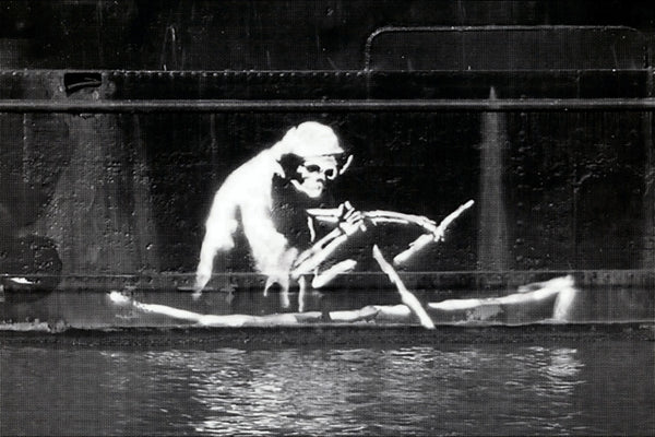 a black and white photo of a monkey in a boat