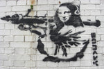 a brick wall with a painting of a woman holding a gun
