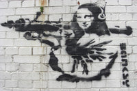 a brick wall with a painting of a woman holding a gun