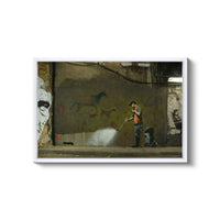 a man spray painting a wall with graffiti