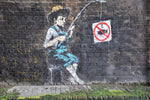 a brick wall with a painting of a man holding a fishing rod
