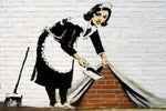 a painting of a woman in an apron is painted on a brick wall