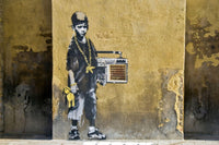 a painting of a man with a boombox on the side of a building