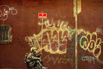 a man sitting on a bench in front of a wall covered in graffiti