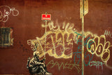 a man sitting on a bench in front of a wall covered in graffiti