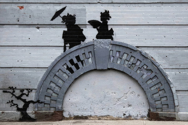 a wall with a painting of two people holding umbrellas