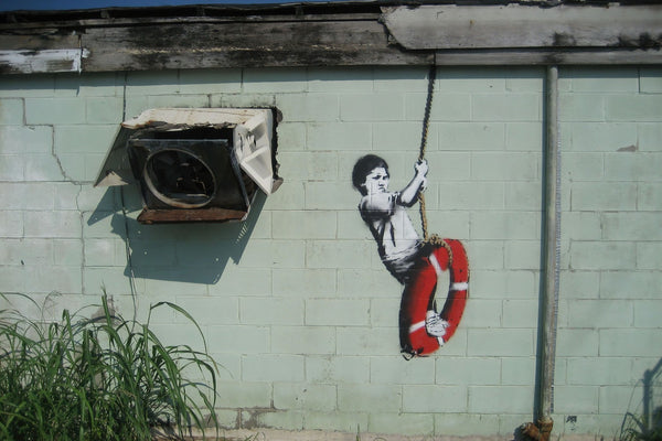 a painting of a boy on a life preserver hangs on a wall