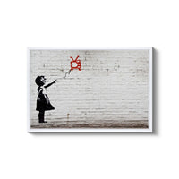 a young girl flying a kite in front of a brick wall