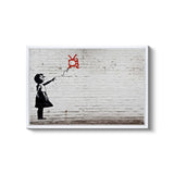 a young girl flying a kite in front of a brick wall