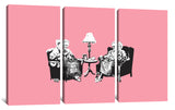 a couple of people sitting next to each other on a pink wall